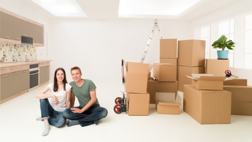 Professional movers loading office equipment into a move van